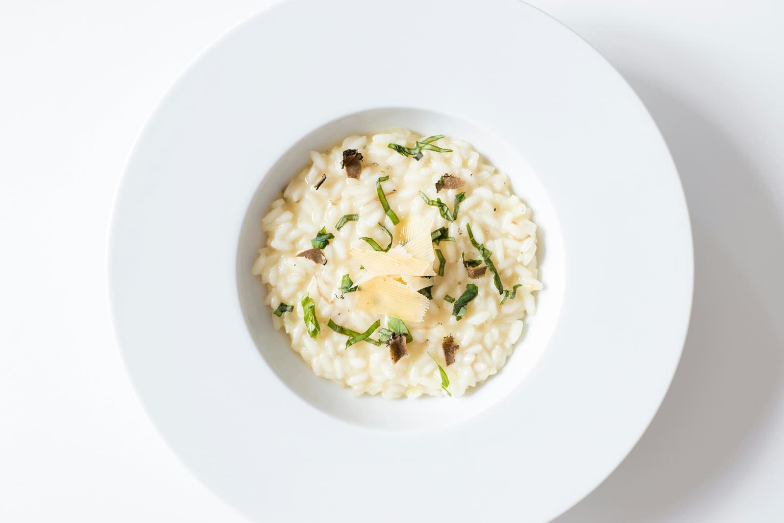 Risotto crémeux au fromage fondu, dressé dans une assiette creuse